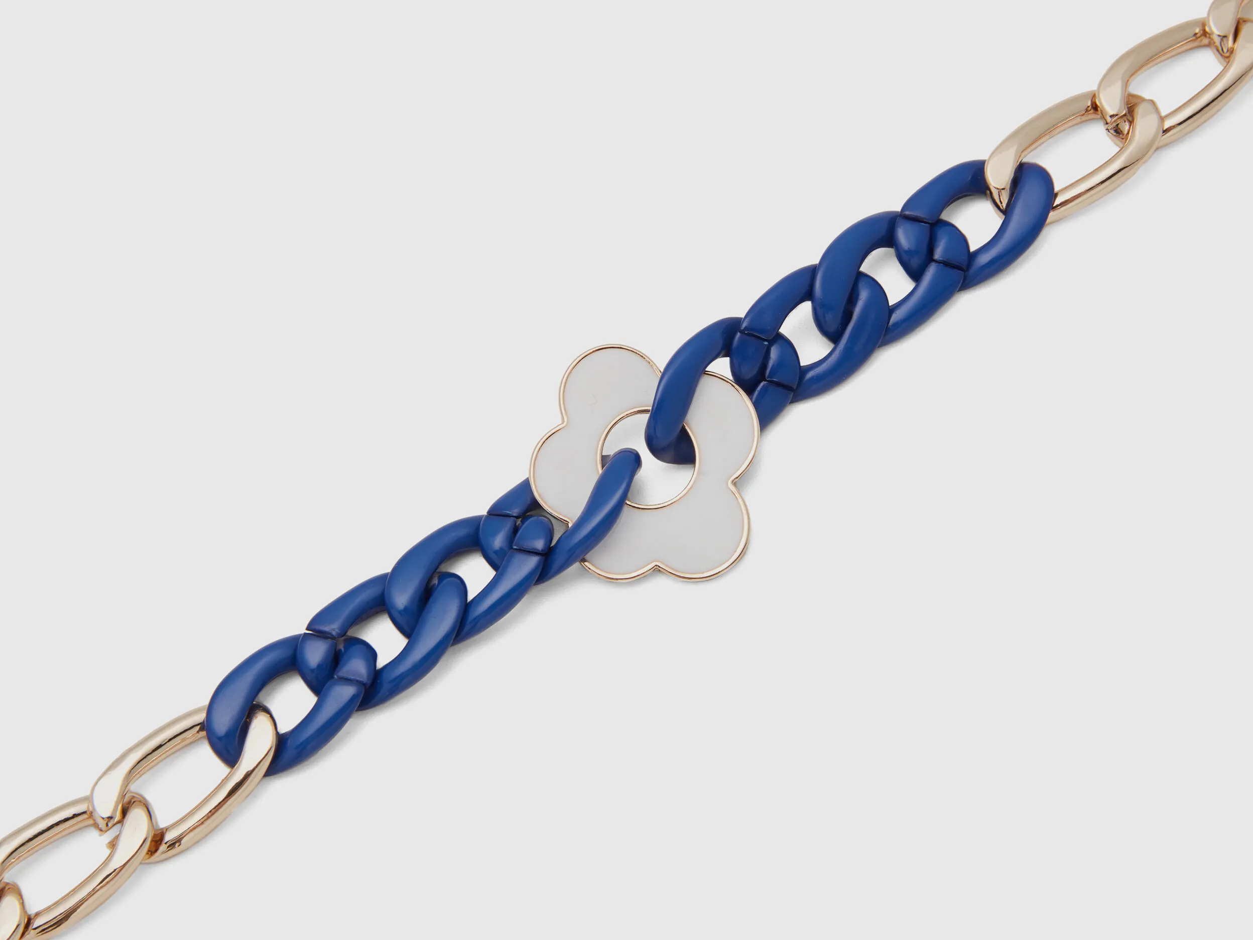 Collar dorado y azul con flor blanca