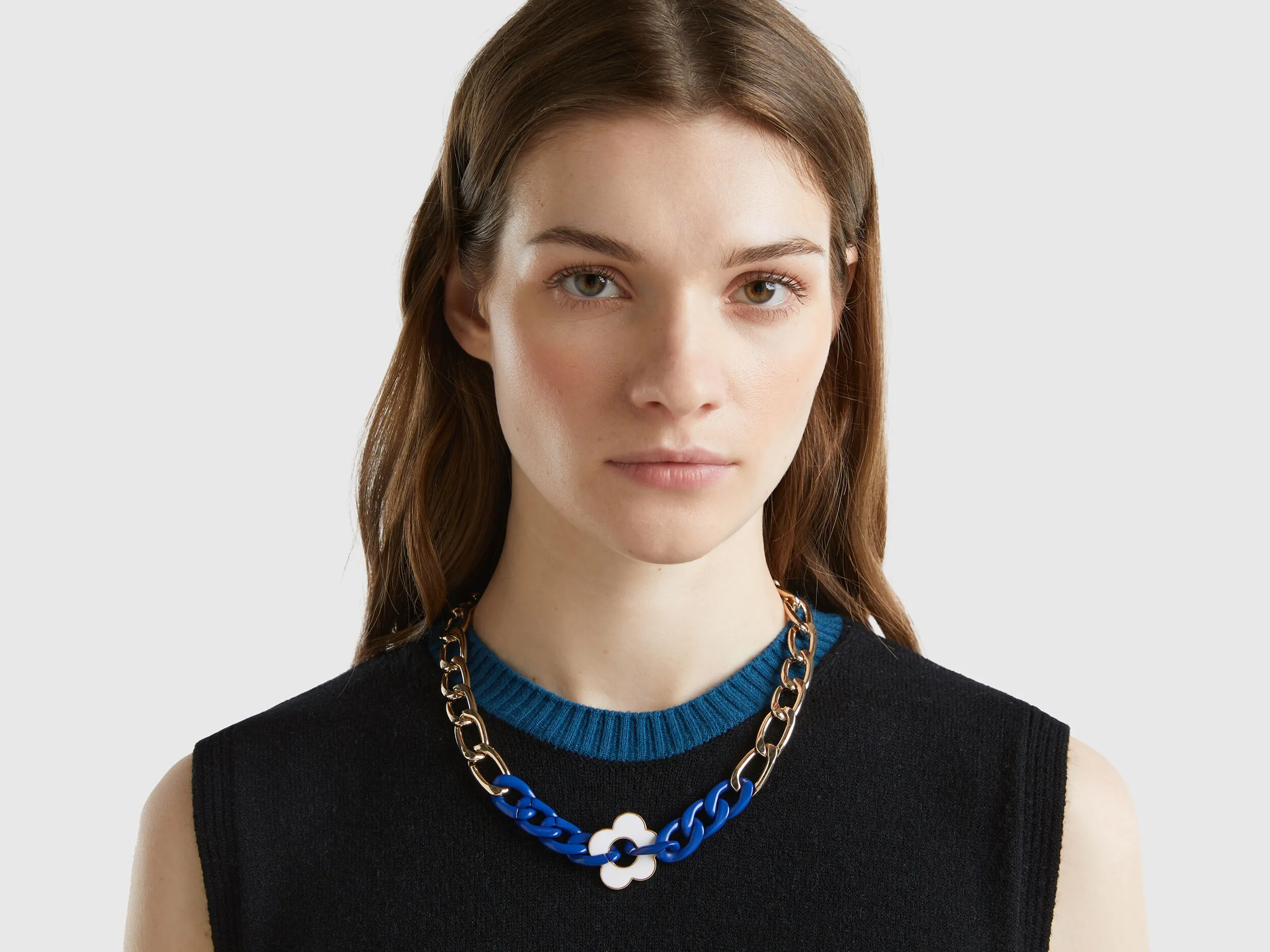 Collar dorado y azul con flor blanca